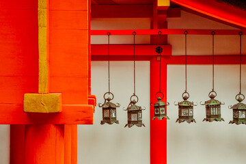 Nara, Japan - 5th March 2018 - A view of lanterns hanging at Kasuga Taisha shrine, framed by red...