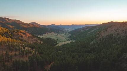 Naklejka premium Overhead shot of a mountain valley at sunrise, with clear sky for copy