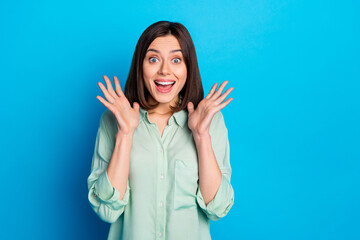 Portrait of ecstatic funky girl with stylish hairdo wear teal shirt raising palms staring at sale...