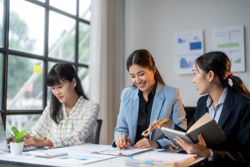 Three young asian businesswomen working together on a new project in office meeting room