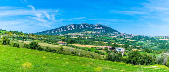 A panorama view towards the limestone escarpment of San Marino, Italy in summertime