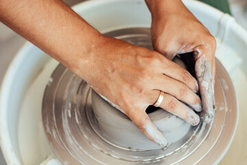 ceramics class, a man makes a clay plate on a potter's wheel