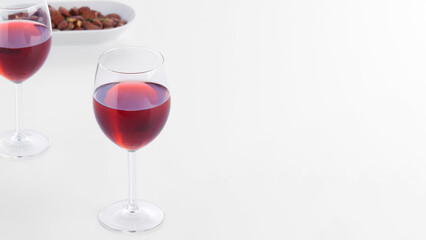 Closeup of two red wine glasses on white kitchen counter.