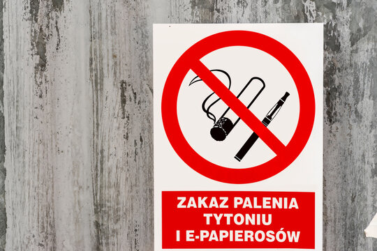 Tablica na ścianie - ZAKAZ PALENIA TYTONIU I E-PAPIEROS&Oacute;W. Plastikowy znak wiszący na ścianie z falistej blachy zakazujący palenia (nawet w nowoczesnej formie) tytoniu.