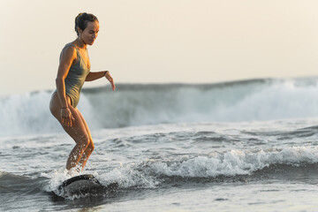 Young woman surfing a wave in the Indian Ocean. Copy space