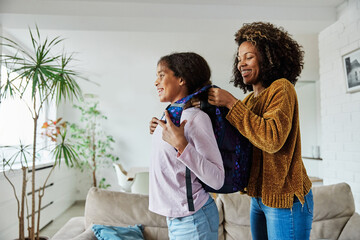 child mother family education school girl home daughter backpack help parent getting ready...