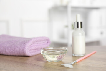 Peeling procedure. Bottle of chemical peel, bowl with liquid, towel and brush on wooden table indoors