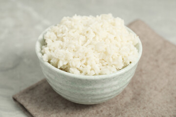 Delicious boiled rice in bowl on grey table, closeup