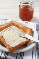 Delicious toasted bread slices with butter served on white table