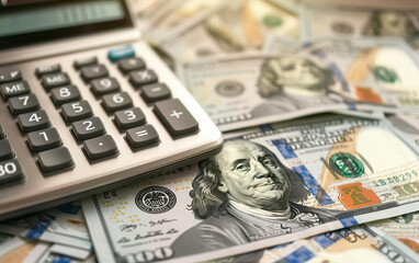 Fototapeta premium Hundreddollar bill and a calculator, budgeting and accounting