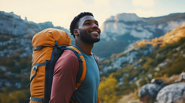 Happy young african american man hiking in the mountains. - Powered by Adobe