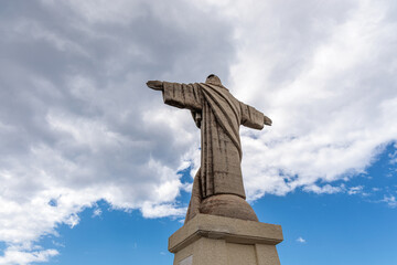 Fototapeta premium Cristo Rei. Jesus monument on top of a cliff overlooking the Atlantic Ocean and a cable car leading down to the beach on the island of Madeira