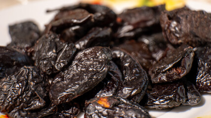 A plate of dried fruit with a black color