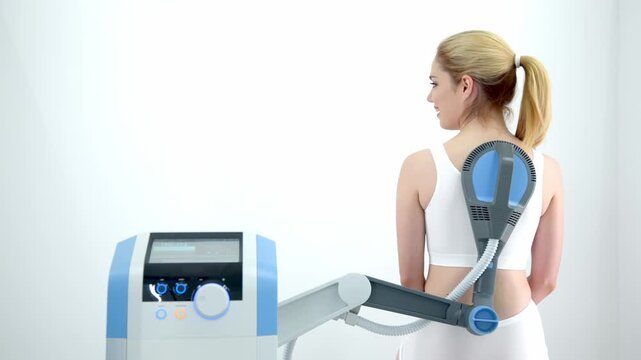 A physiotherapist administers advanced electromagnetic therapy for back pain relief using state-of-the-art equipment. Ideal for showcasing effective pain management and rehabilitation techniques.