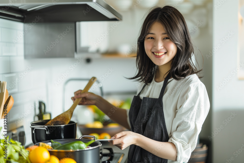 Wall mural young japanese woman cooking in a modern kitchen with fresh ingredients