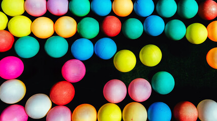 Top view of many colorful plastic balls on water. View of colored sponge balls. Many colorful balls as background. Lots of colorful balls for children to play in the water park. Toy pool for kids.