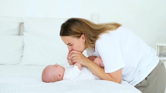 mom and baby, a young beautiful mom with a little boy hugging and playing at home in the bedroom, maternal care and love, portrait of a happy mother with a child, healthy motherhood