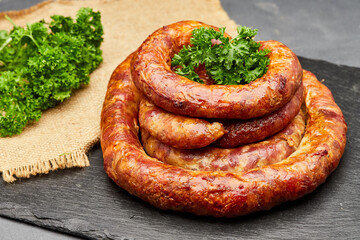 Savory grilled sausage garnished with fresh parsley on a slate board