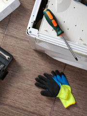 Close-up a screwdriver lying on a disassembled washing machine. Professional repair of household appliances.