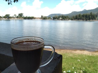 Black Coffee
A glass of black coffee with a lake in the background