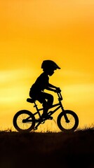 Obraz premium Silhouette Balance Bike Adventure, a young boy honing his balance skills on a unique bike design, featuring a plowed leg for stability, encouraging confidence in cycling.