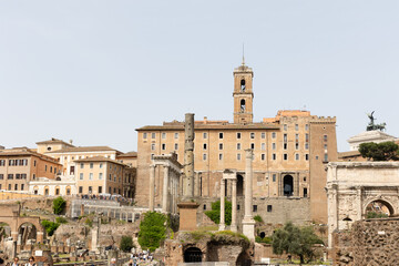 Fototapeta premium Rome, Italy - April 09, 2024: Ruins of the Roman Forum with tourists strolling among the archaeological remains in Rome, Italy