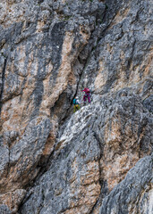 Two rock climbers climb a massive cliff on a sunny day. Extreme sports