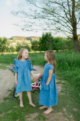 Obraz premium two sisters with bicycle and flowers