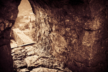 Loophole
 in the massive stone wall of medieval fortress. Old Bar, Montenegro