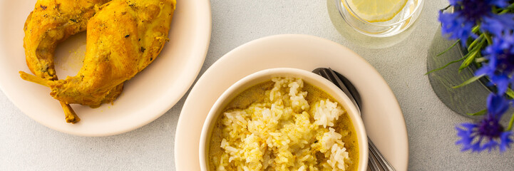 Stewed rabbit with rice, broccoli and rice cakes, a served table with food and a vase of flowers, a delicious hearty lunch or dinner, banner