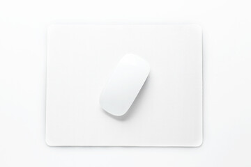 Wireless mouse and mousepad on white background, top view