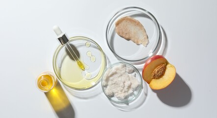 Petri dishes with different cosmetic products and peach on white background, flat lay