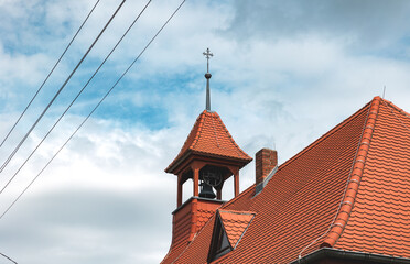 Church tower with a cross on the top and a bell in the steeple in Dessau, Saxony-Anhalt, Germany....
