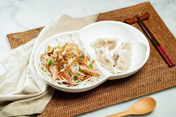 Sakura Shrimp Sauce Crab Meat Rice Noodles with Dumplings, chopsticks and spoon served in dish isolated on napkin side view of Chinese food