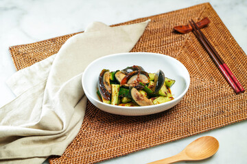 Spicy Cucumber and Preserved Egg with Chilli sauce chopsticks and spoon served in dish isolated on napkin side view of Chinese food