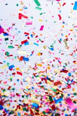 Obraz premium Colorful confetti falling on a white background.
