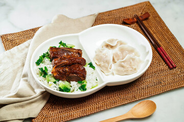Zhenjiang bone vegetable rice with Steamed dumplings, chopsticks and spoon served in dish isolated on napkin side view of Chinese food