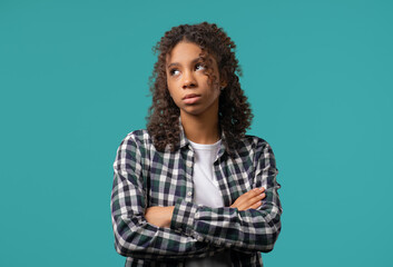 Bored upset african woman sighs, rolling eyes on blue. Teenager in displeasure
