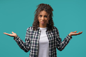 Confused african teenager girl,shoulders up - can't help,makes gesture dont know