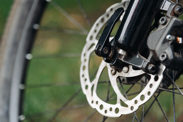 Fototapeta premium Bicycle wheel on grass, bicycle gear, disc brake pads, mountain bike wheel closeup,