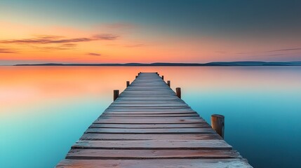 Naklejka premium Wooden pier extending over calm water at sunset. background with beautiful landscape
