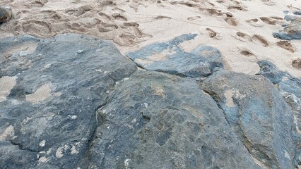 A rocky beach with a large rock in the foreground