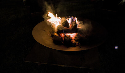 fire burning in fire pit (logs wood flame flames rising hot summer recreation) back yard patio © Yuriy T
