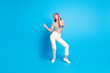 Full body portrait of nice young lady dancing headphones wear top isolated on blue color background