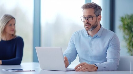 A businessman working on his laptop in a modern office setting.