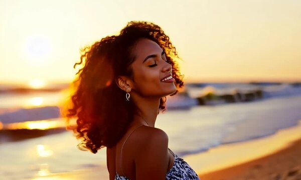 Smiling young woman with curly hair enjoying a sunset at the beach, radiating joy and warmth