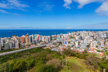 Fototapeta premium Aerial view of Vila Velha from Convento da Penha on a sunny day, highlighting Praia da Costa and Itapuã neighborhoods with the blue ocean in the background. Perfect blend of urban and coastal beauty.