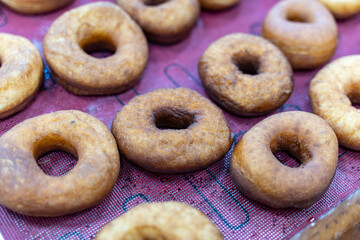 Donuts ready to be decorated with icing, donut production process.