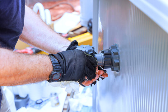 An installation technician installs water filtration system, chlorination system in pool frame
