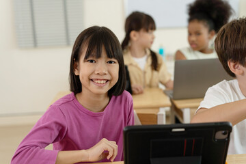 Smiling Asian Girl Using Tablet in Technology Interactive Elementary Class in School